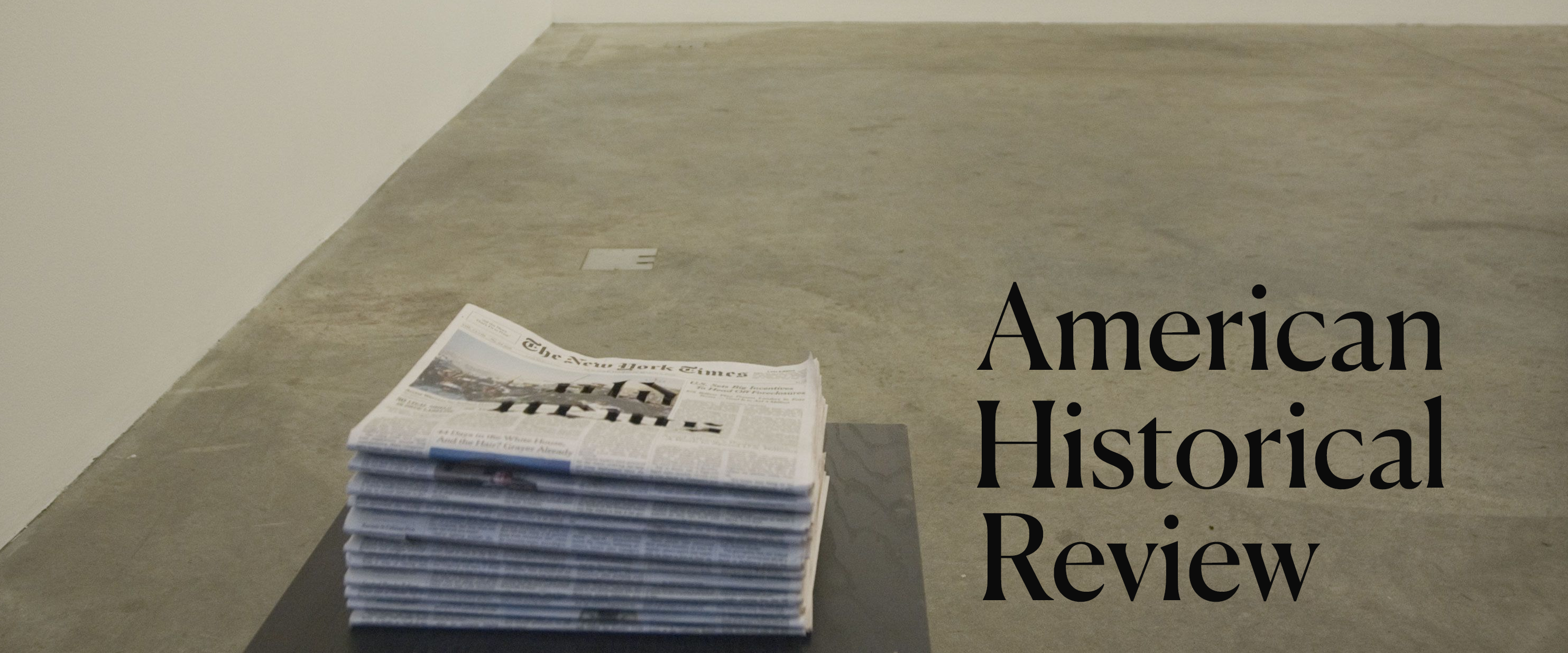 A table with a stack of newspapers next to the text American Historical Review